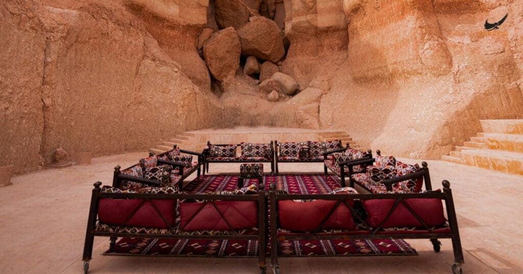 Traditional Bedouin seating area inside a desert cave with cushions and carpets.