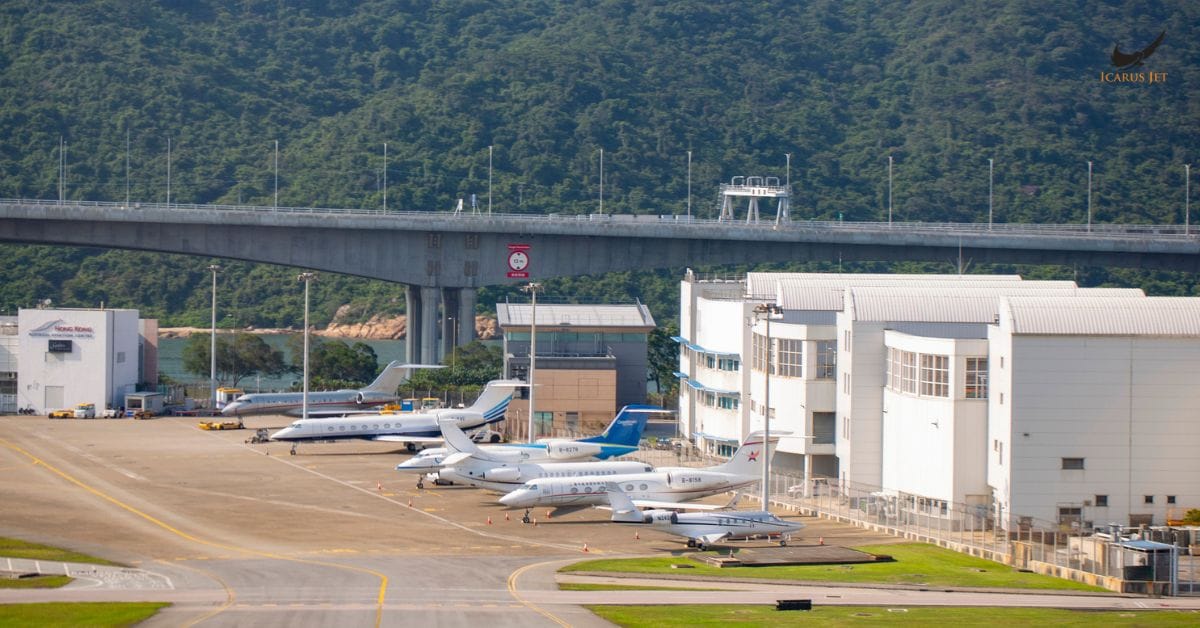 private jets parked at airport apron near hangars