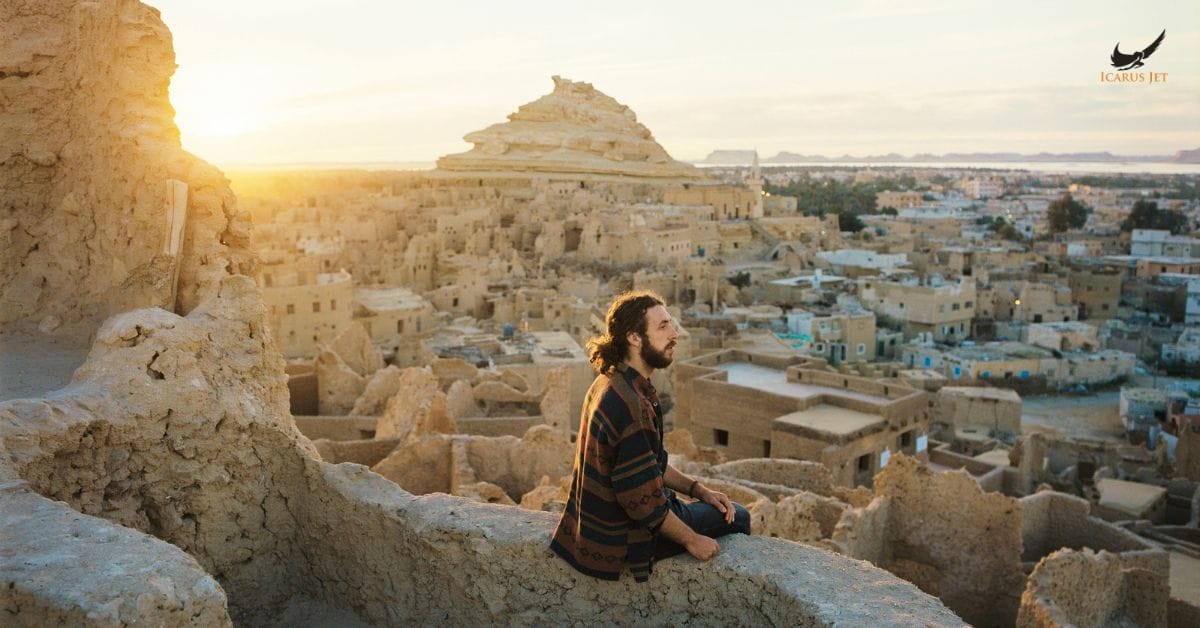 man overlooking historic Siwa with Citadel at sunset