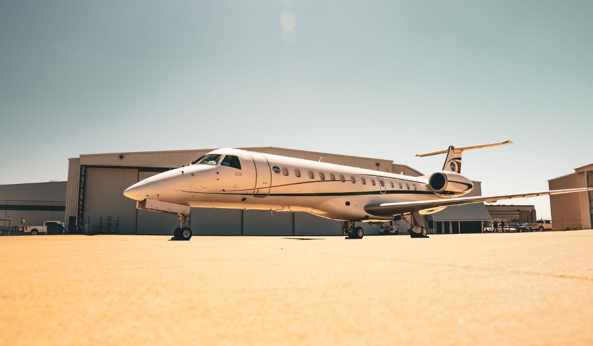 Side view of a private jet parked on a bright airport tarmac