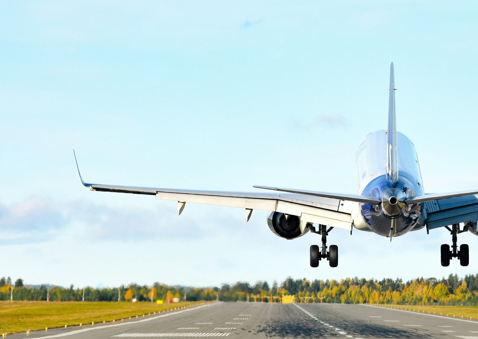 Dallas Executive Airport (RBD / KRBD): airliner passing low over the runway threshold on approach above green fields