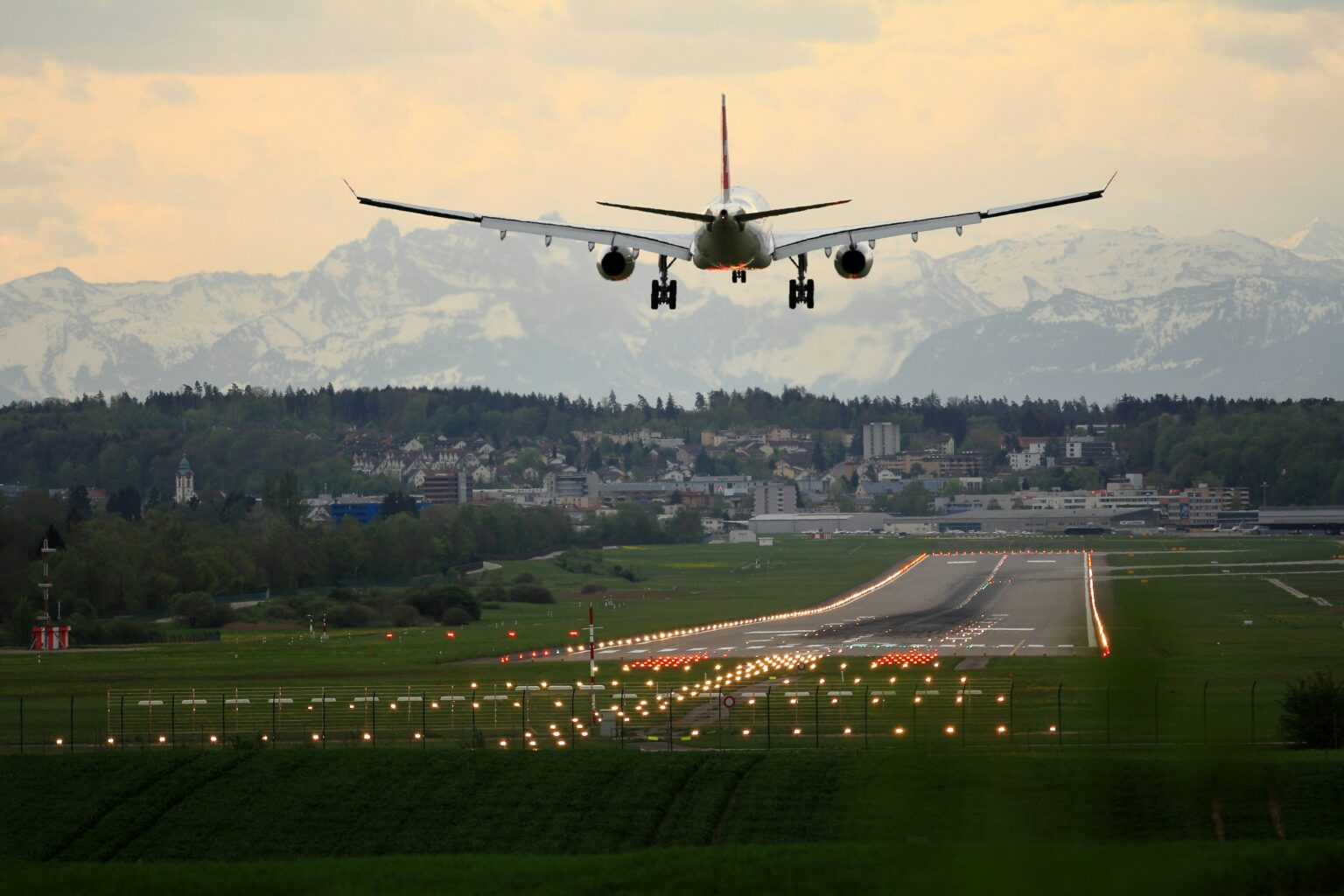 Rifle Garfield County Airport (RIL / KRIL): aircraft on final approach over mountains with runway approach lights at dusk