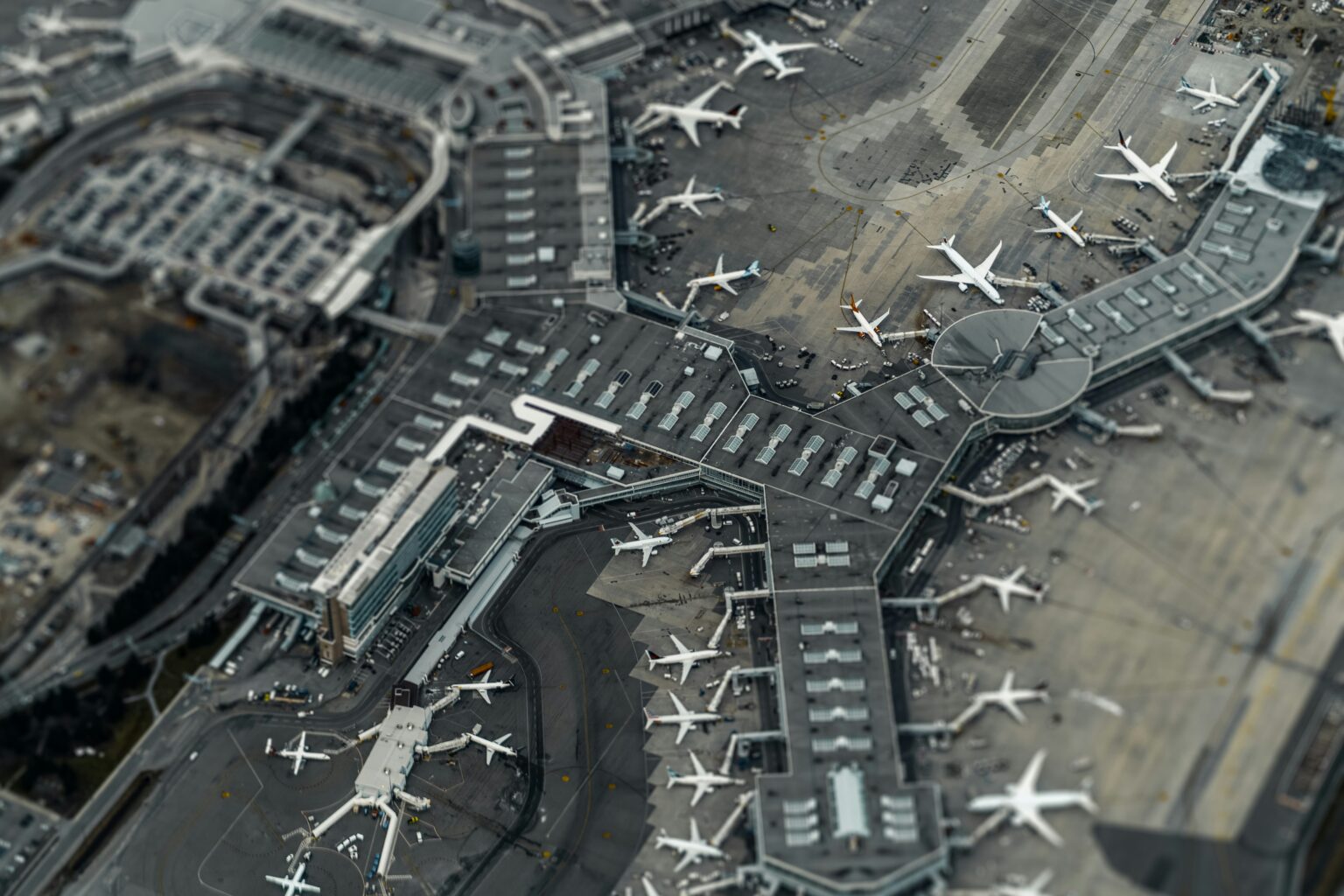 Dallas Fort Worth International Airport (DFW / KDFW): aerial view of an airport terminal complex with aircraft at gates and taxiways between piers