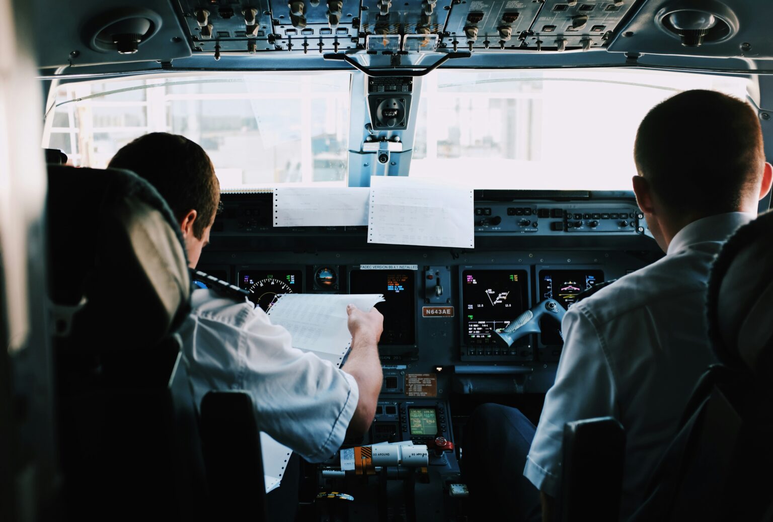 King Fahd International Airport (DMM / OEDF): flight crew in the cockpit reviewing trip documents before departure