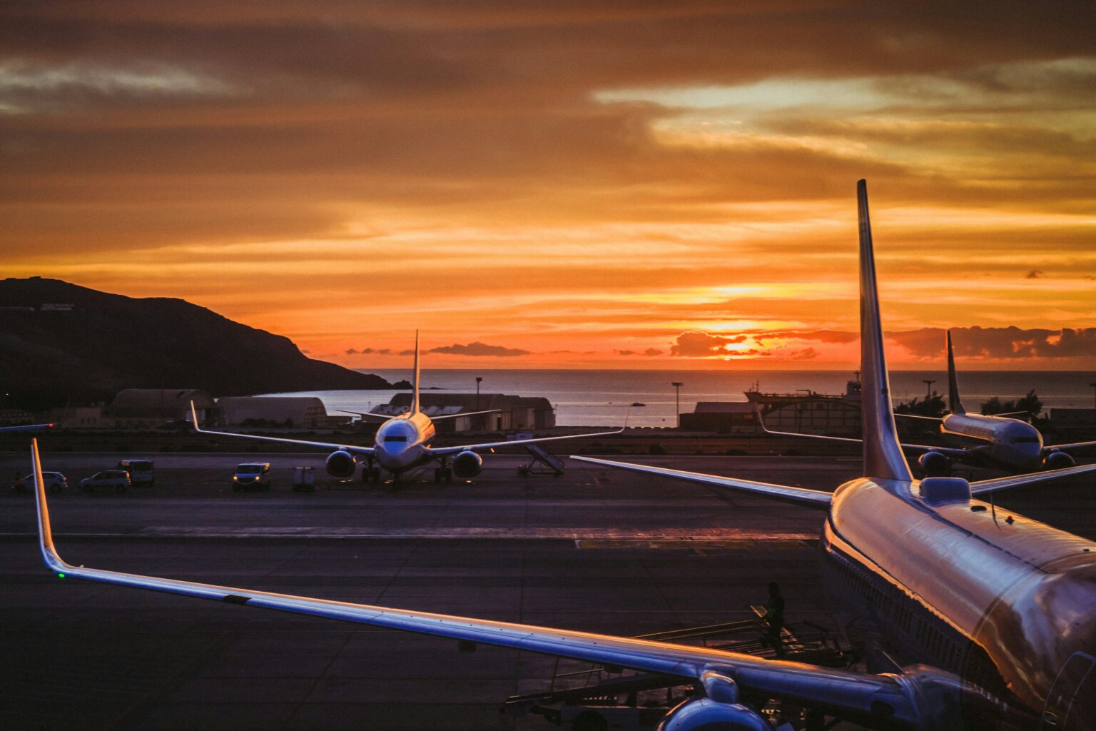 Geneva Airport (GVA / LSGG): aircraft on the ramp at sunset seen past a wingtip